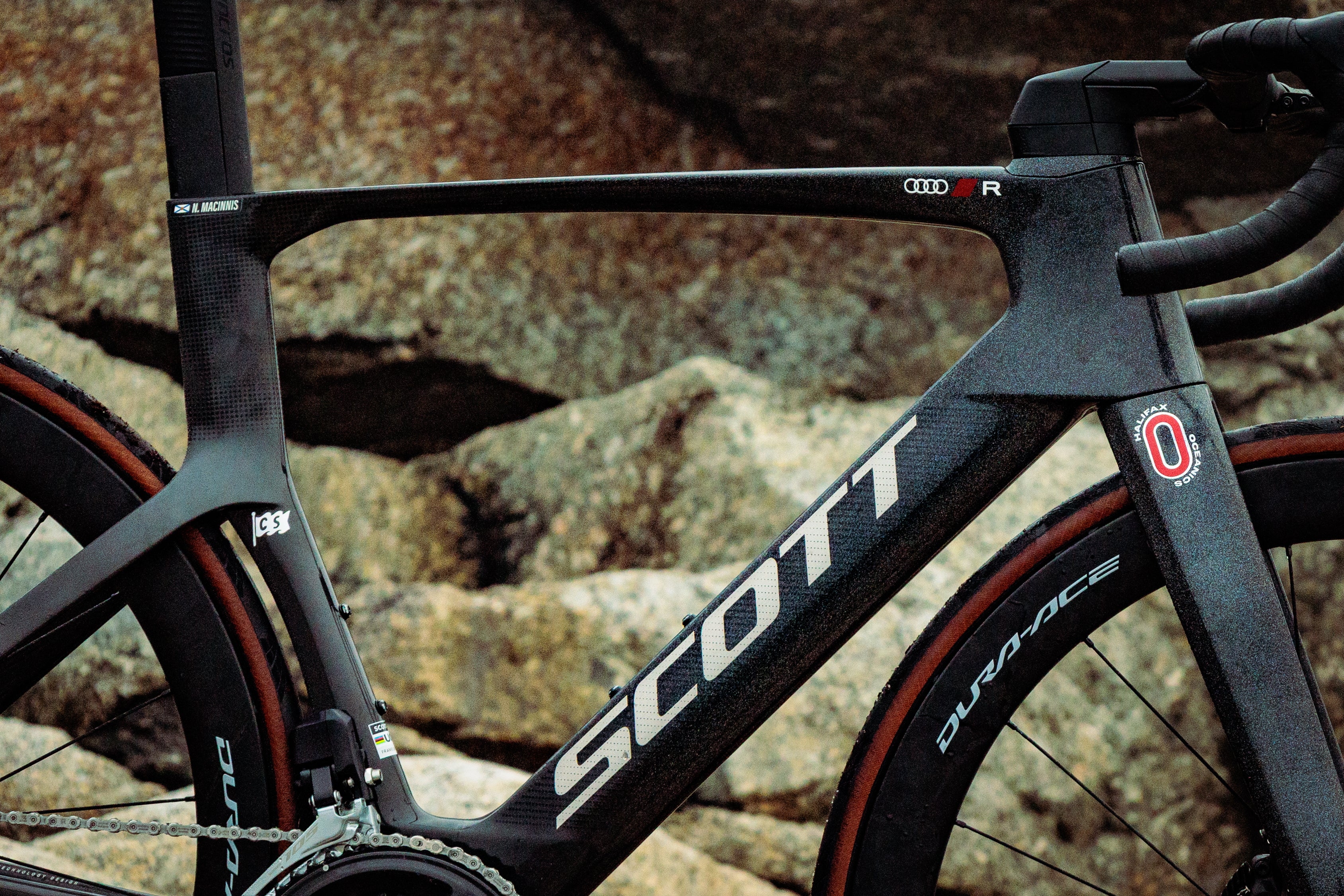 Black Scott road bike with name bar, club logo, sponsor, and holographic Coastal Spirit flag decals